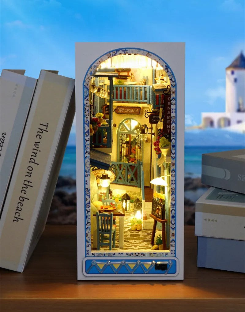 DIY and crafts lovers will enjoy this miniature book nook kit — a charming Mediterranean street scene that doubles as a bookshelf insert or home decor; perfect for craft ideas and making miniatures.