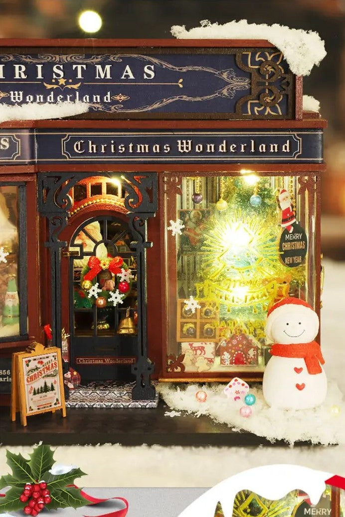 DIY miniature Christmas shop called “Jolly & Pine Christmas Shoppe,” featuring snow-dusted rooftops, holiday lights, a sleigh, Christmas tree, and cozy window displays. Ideal for holiday crafts, DIY mini home kits, and miniature house collectors.
