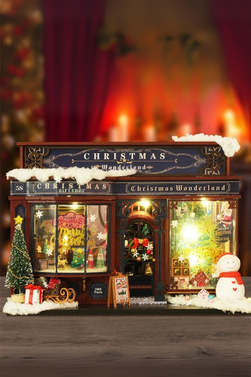 DIY miniature Christmas shop called “Jolly & Pine Christmas Shoppe,” featuring snow-dusted rooftops, holiday lights, a sleigh, Christmas tree, and cozy window displays. Ideal for holiday crafts, DIY mini home kits, and miniature house collectors.