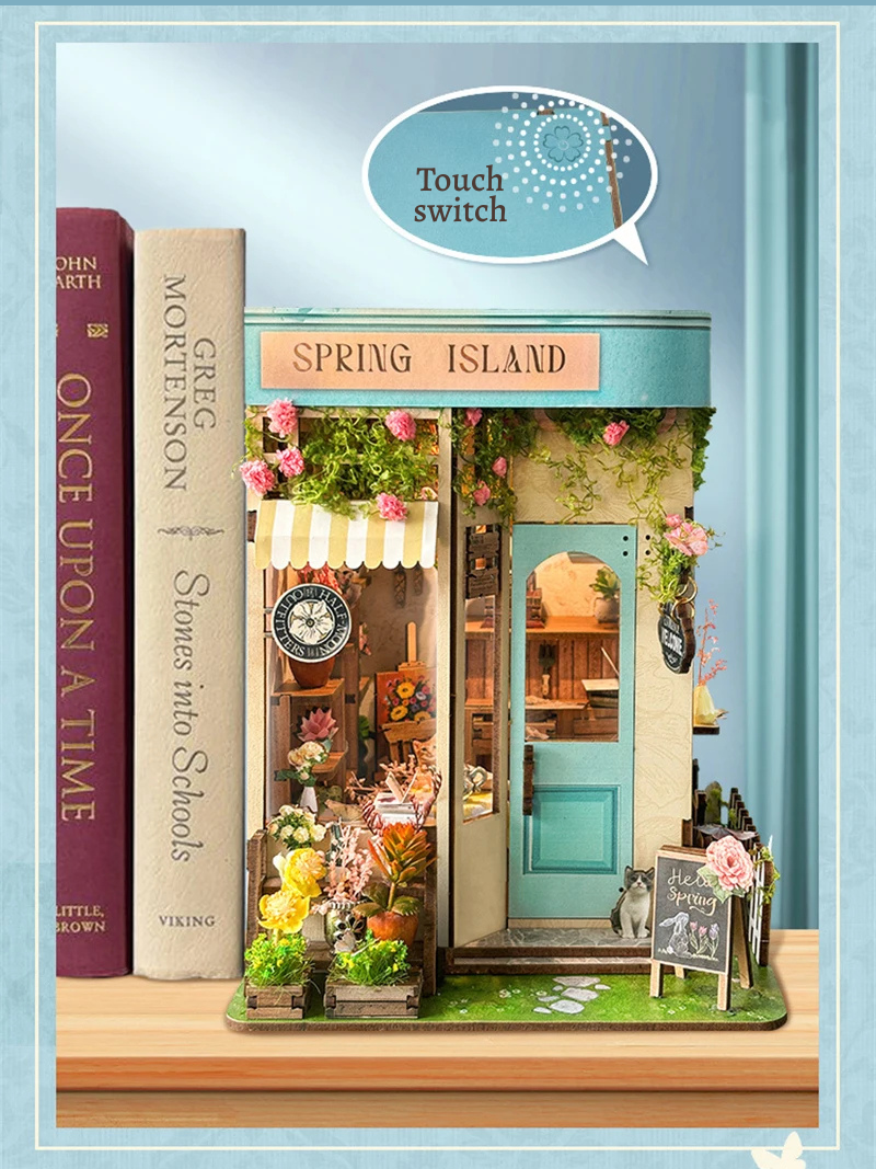 DIY book nook kit “Springkeeper’s Shop” featuring a cheerful miniature flower store with potted plants, blooming flowers, a striped awning, and a small cat. A charming craft idea for DIY and crafts lovers, perfect for fans of miniatures and DIY tiny home kits.