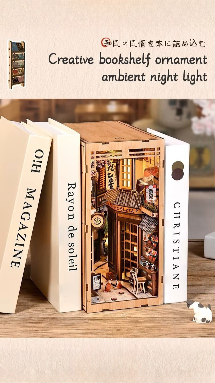 DIY book nook kit “Neko Alley Nook,” featuring a Japanese alleyway with miniature shopfronts, paper lanterns, wooden signage, and lounging cats. A charming DIY and crafts project for Japan enthusiasts and book nook collectors.
