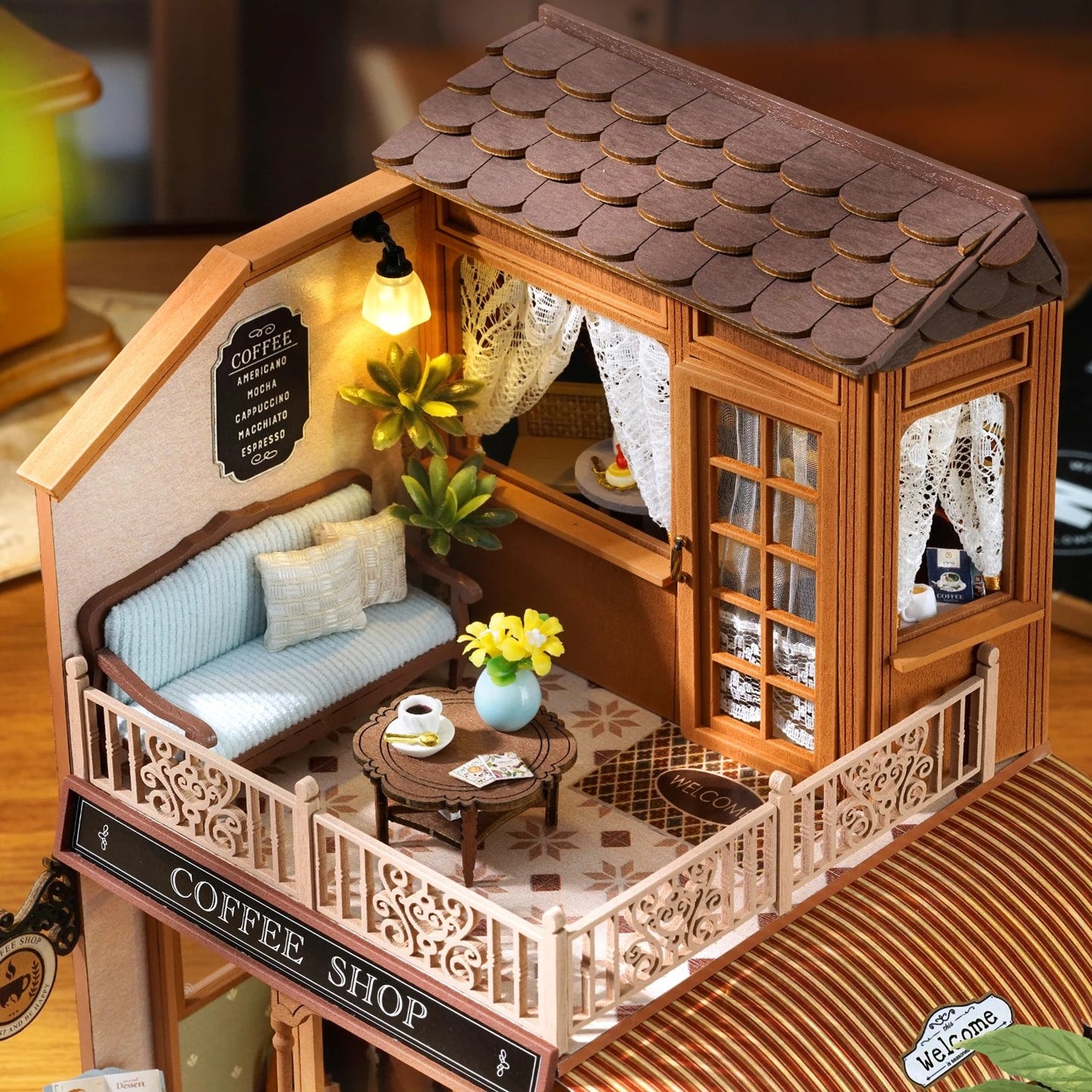 DIY mini house kit “Perch & Latte Loft,” featuring a cozy two-story coffee shop with a glowing café interior, reading nook, lace-curtained loft, and tiny desserts. A warm and detailed build for DIY and crafts lovers and fans of miniature homes.