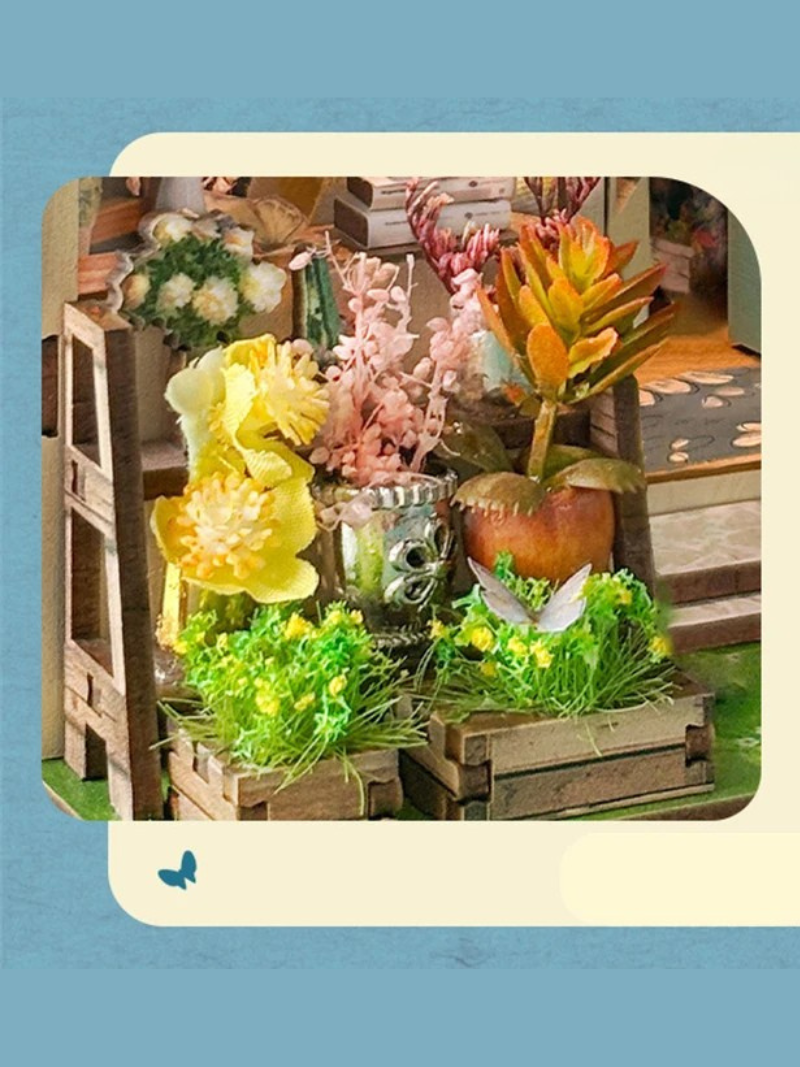 DIY book nook kit “Springkeeper’s Shop” featuring a cheerful miniature flower store with potted plants, blooming flowers, a striped awning, and a small cat. A charming craft idea for DIY and crafts lovers, perfect for fans of miniatures and DIY tiny home kits.
