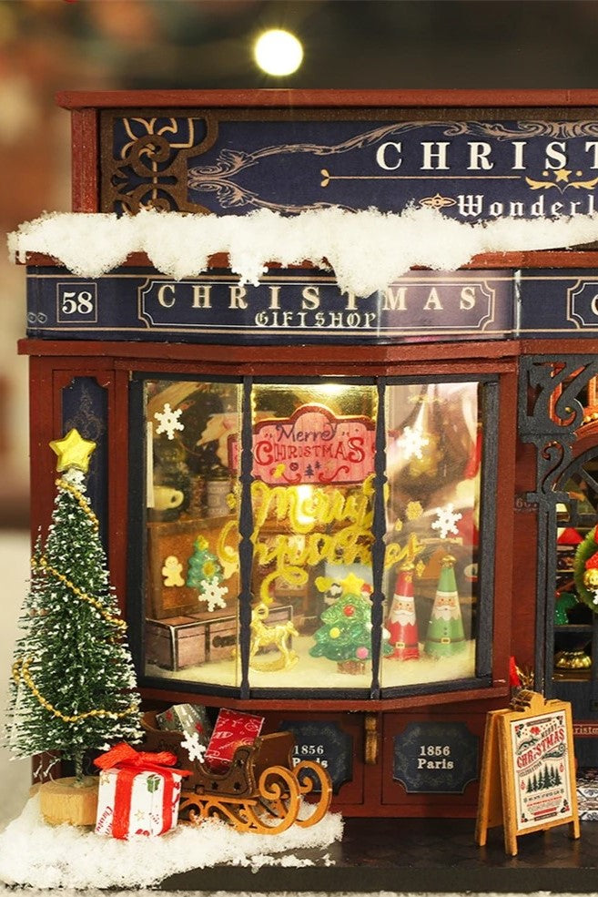 DIY miniature Christmas shop called “Jolly & Pine Christmas Shoppe,” featuring snow-dusted rooftops, holiday lights, a sleigh, Christmas tree, and cozy window displays. Ideal for holiday crafts, DIY mini home kits, and miniature house collectors.