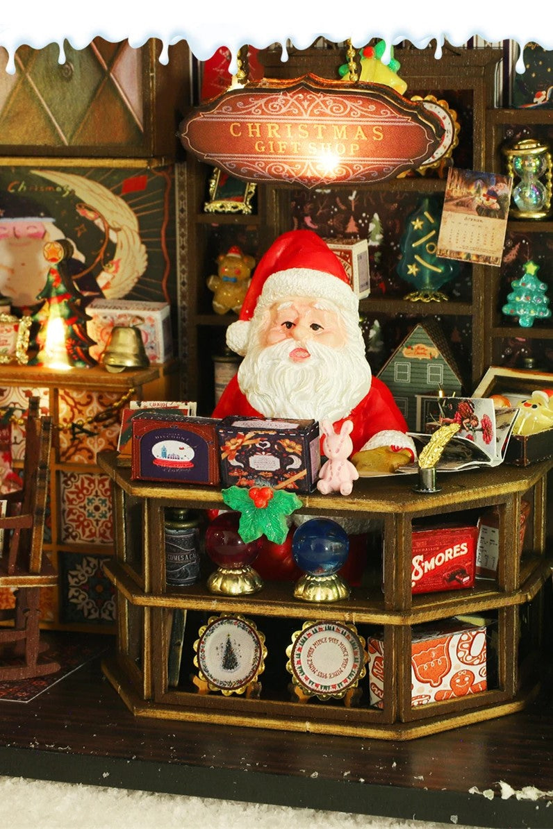 DIY miniature Christmas shop called “Jolly & Pine Christmas Shoppe,” featuring snow-dusted rooftops, holiday lights, a sleigh, Christmas tree, and cozy window displays. Ideal for holiday crafts, DIY mini home kits, and miniature house collectors.