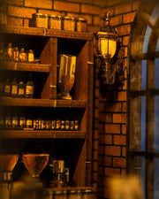 Miniature DIY book nook of a dark vintage-style café with glowing warm lights, ornate black storefront, and a coffee sign that reads “Jadeite Coffee.”