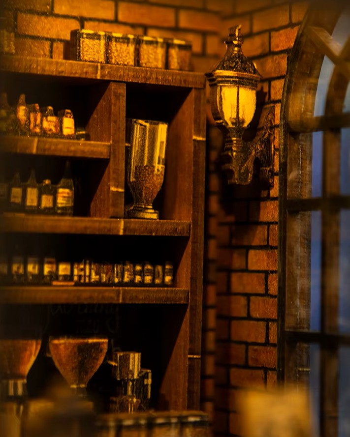 Miniature DIY book nook of a dark vintage-style café with glowing warm lights, ornate black storefront, and a coffee sign that reads “Jadeite Coffee.”