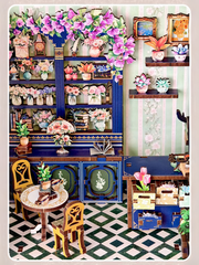 DIY book nook kit “Maison de Fleurs,” featuring a pastel-toned miniature flower shop with arched windows, blooming plants, stone accents, and romantic signage. A relaxing DIY and crafts project for fans of tiny dollhouses and garden-inspired scenes.