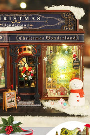 DIY miniature Christmas shop called “Jolly & Pine Christmas Shoppe,” featuring snow-dusted rooftops, holiday lights, a sleigh, Christmas tree, and cozy window displays. Ideal for holiday crafts, DIY mini home kits, and miniature house collectors.