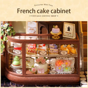 DIY mini house kit “Perch & Latte Loft,” featuring a cozy two-story coffee shop with a glowing café interior, reading nook, lace-curtained loft, and tiny desserts. A warm and detailed build for DIY and crafts lovers and fans of miniature homes.