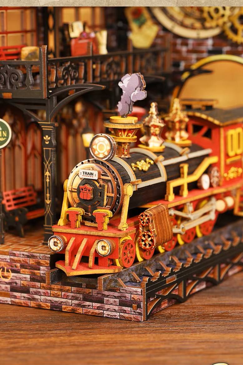 DIY book nook kit “Platform Arcane,” featuring a mechanical fantasy train station with glowing lights, gears, arched glass roof, red locomotive, and magical details. Ideal for DIY and crafts lovers, fantasy readers, and miniature train enthusiasts.
