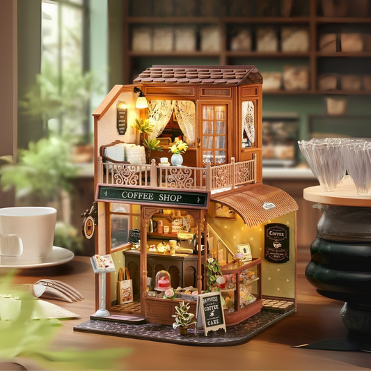 DIY mini house kit “Perch & Latte Loft,” featuring a cozy two-story coffee shop with a glowing café interior, reading nook, lace-curtained loft, and tiny desserts. A warm and detailed build for DIY and crafts lovers and fans of miniature homes.