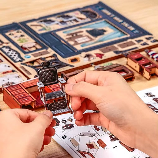 DIY book nook kit “Pomade Parlor,” featuring a vintage barbershop and hair salon interior with red chairs, mirrors, wooden shelves, and miniature grooming tools. A nostalgic DIY and crafts project for fans of retro style, miniatures, and classic salon design.