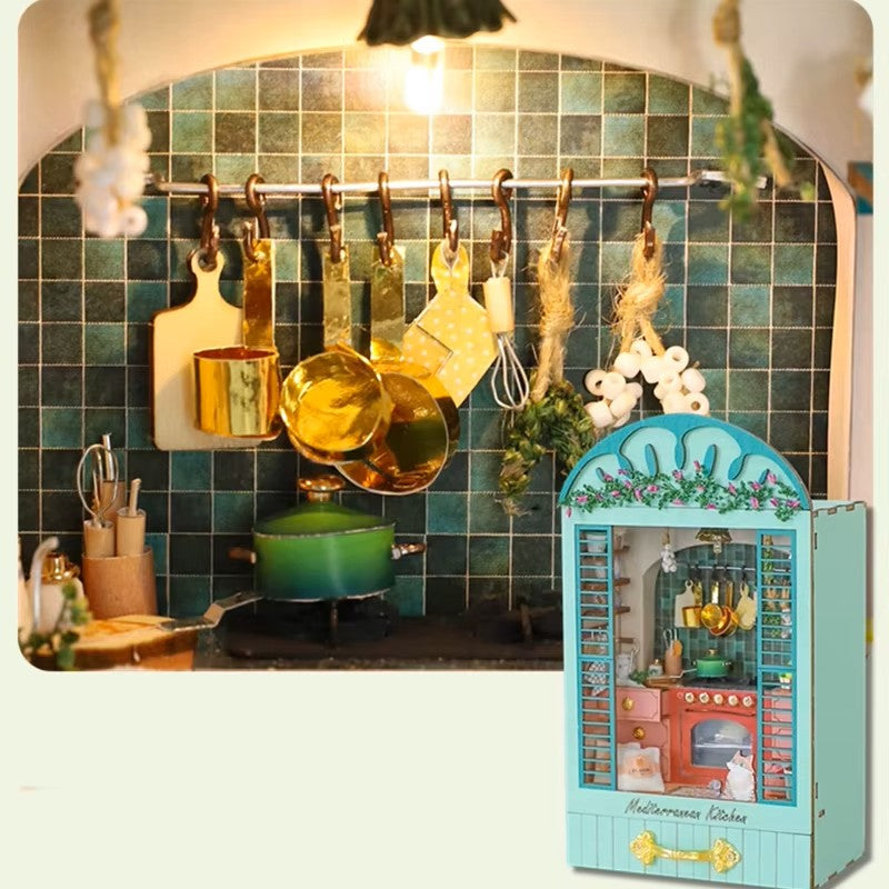 DIY book nook miniature kitchen with Mediterranean tiles, hanging copper pots, red oven, and open blue shutters.