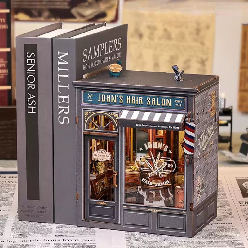 DIY book nook kit “Pomade Parlor,” featuring a vintage barbershop and hair salon interior with red chairs, mirrors, wooden shelves, and miniature grooming tools. A nostalgic DIY and crafts project for fans of retro style, miniatures, and classic salon design.