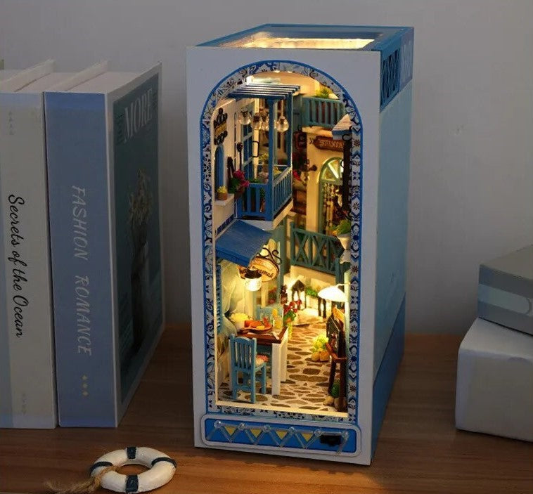 DIY and crafts lovers will enjoy this miniature book nook kit — a charming Mediterranean street scene that doubles as a bookshelf insert or home decor; perfect for craft ideas and making miniatures.