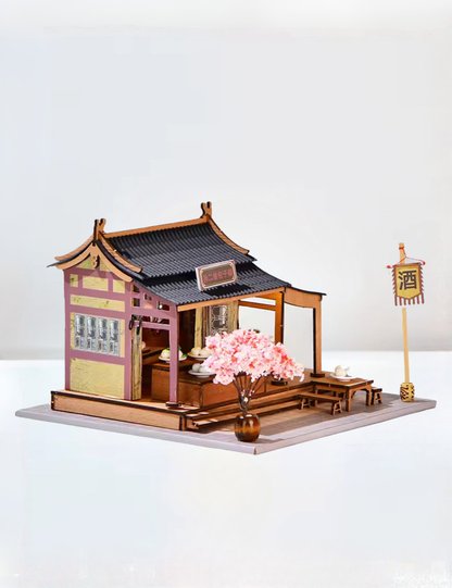 DIY mini house kit “Little Bao Shop,” featuring a traditional Chinese dumpling stand with miniature steamed buns, wooden tables, hanging signs, and a cherry blossom tree—perfect for DIY food miniatures and cultural craft ideas.