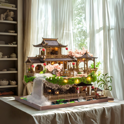 DIY miniature kit “Blossom Lantern Pavilion,” featuring a traditional East Asian-style building with curved roofs, cherry blossom trees, red lanterns, a waterfall, and glowing lights. A serene DIY and crafts project for fans of miniature homes and nature-inspired design.