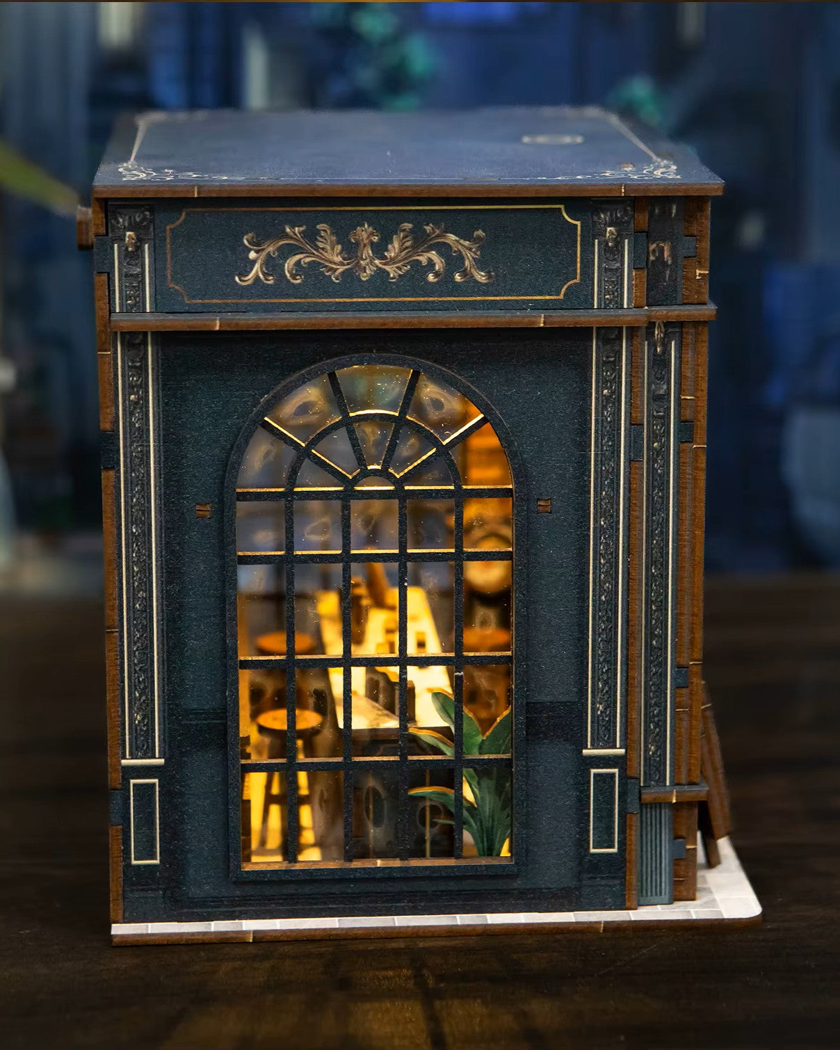 Miniature DIY book nook of a dark vintage-style café with glowing warm lights, ornate black storefront, and a coffee sign that reads “Jadeite Coffee.”