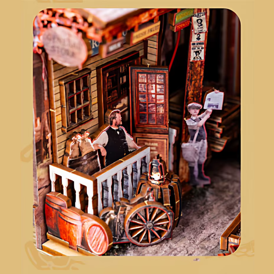 DIY miniature book nook of a Wild West street scene featuring a saloon façade with swinging doors, wooden signage, warm lantern lighting, and rustic storefront details, evoking a classic frontier town at dusk.