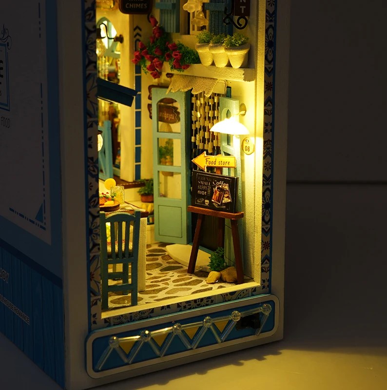 DIY and crafts lovers will enjoy this miniature book nook kit — a charming Mediterranean street scene that doubles as a bookshelf insert or home decor; perfect for craft ideas and making miniatures.