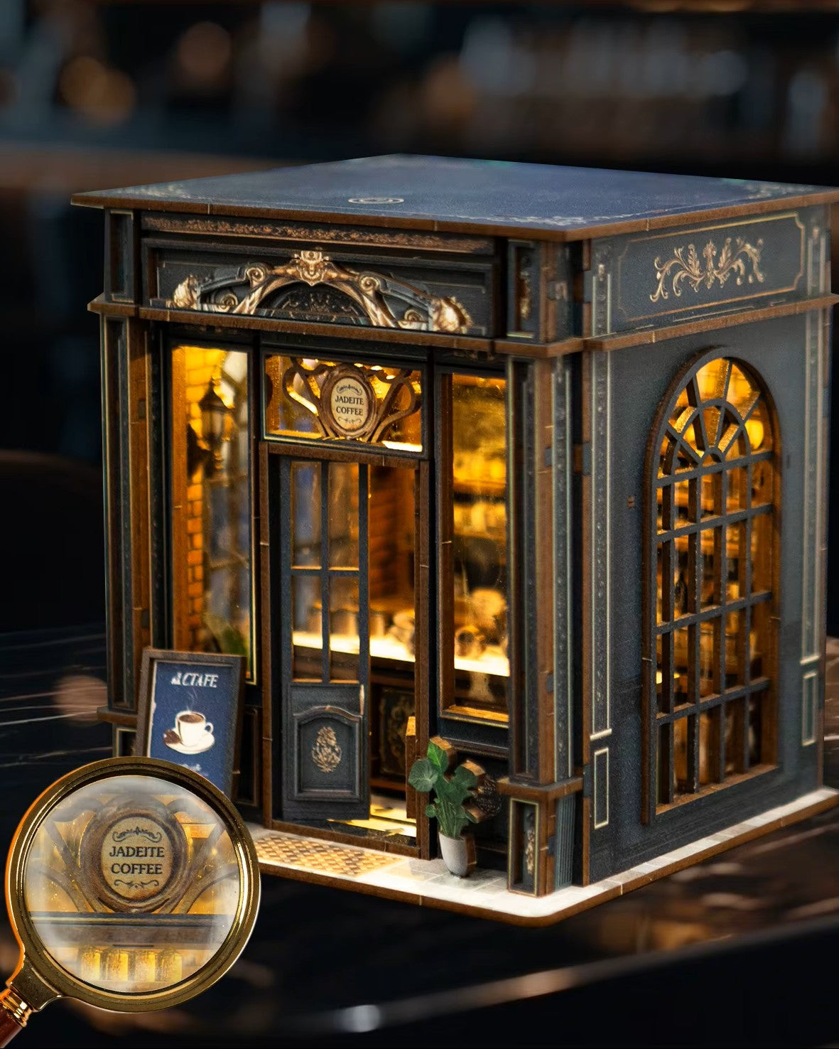 Miniature DIY book nook of a dark vintage-style café with glowing warm lights, ornate black storefront, and a coffee sign that reads “Jadeite Coffee.”