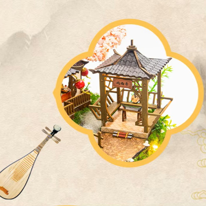 DIY miniature kit “Blossom Lantern Pavilion,” featuring a traditional East Asian-style building with curved roofs, cherry blossom trees, red lanterns, a waterfall, and glowing lights. A serene DIY and crafts project for fans of miniature homes and nature-inspired design.