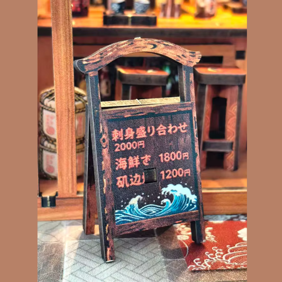 DIY miniature sake bar book nook with glowing lanterns, wooden bar seating, bamboo paneling, and rows of sake bottles, capturing the quiet atmosphere of a late-night Japanese tavern.