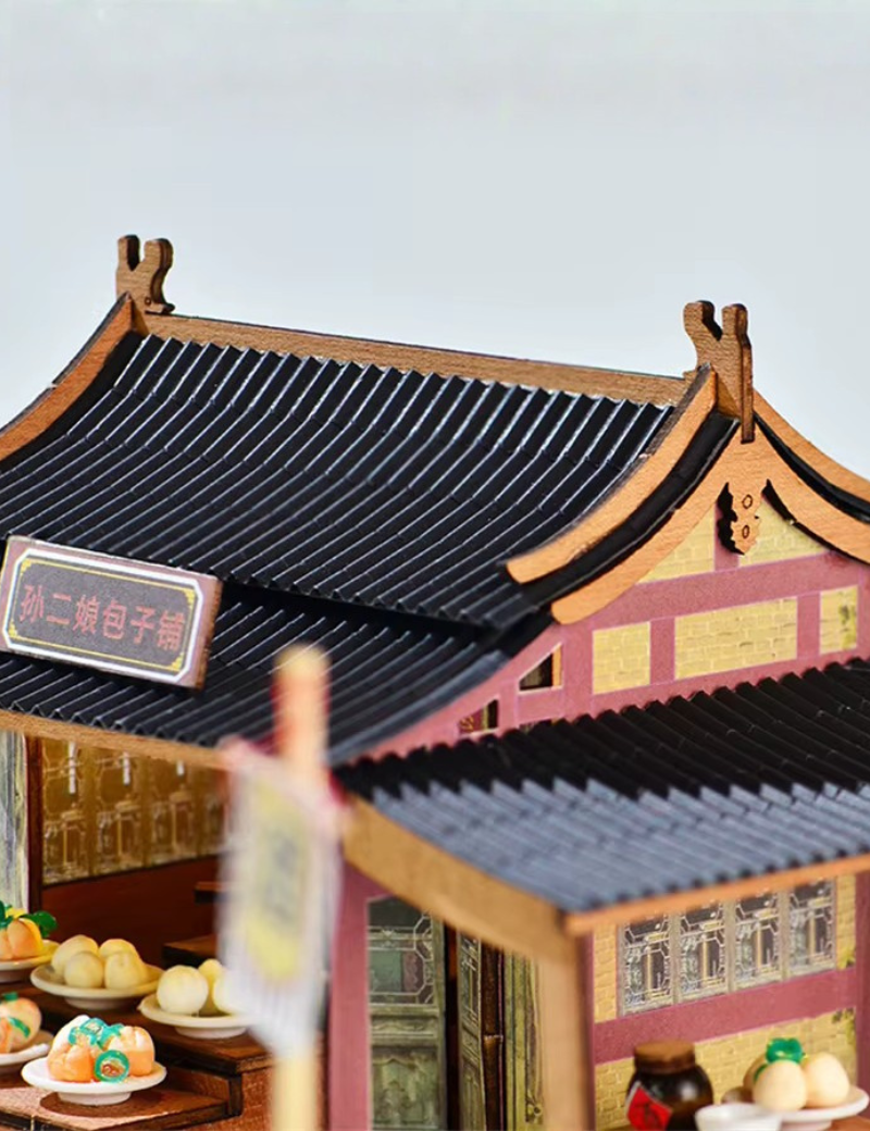 DIY mini house kit “Little Bao Shop,” featuring a traditional Chinese dumpling stand with miniature steamed buns, wooden tables, hanging signs, and a cherry blossom tree—perfect for DIY food miniatures and cultural craft ideas.