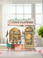 DIY book nook kit “Maison de Fleurs,” featuring a pastel-toned miniature flower shop with arched windows, blooming plants, stone accents, and romantic signage. A relaxing DIY and crafts project for fans of tiny dollhouses and garden-inspired scenes.