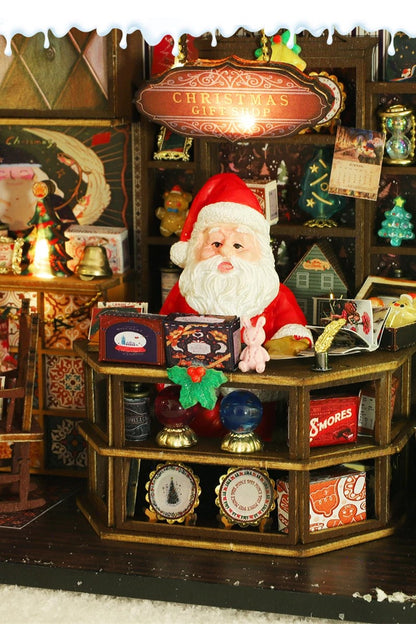 DIY miniature Christmas shop called “Jolly & Pine Christmas Shoppe,” featuring snow-dusted rooftops, holiday lights, a sleigh, Christmas tree, and cozy window displays. Ideal for holiday crafts, DIY mini home kits, and miniature house collectors.