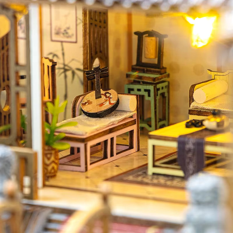DIY miniature kit “Blossom Lantern Pavilion,” featuring a traditional East Asian-style building with curved roofs, cherry blossom trees, red lanterns, a waterfall, and glowing lights. A serene DIY and crafts project for fans of miniature homes and nature-inspired design.