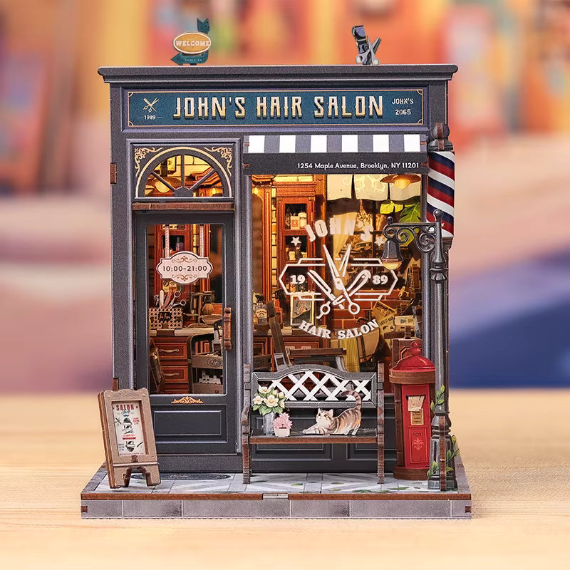 DIY book nook kit “Pomade Parlor,” featuring a vintage barbershop and hair salon interior with red chairs, mirrors, wooden shelves, and miniature grooming tools. A nostalgic DIY and crafts project for fans of retro style, miniatures, and classic salon design.