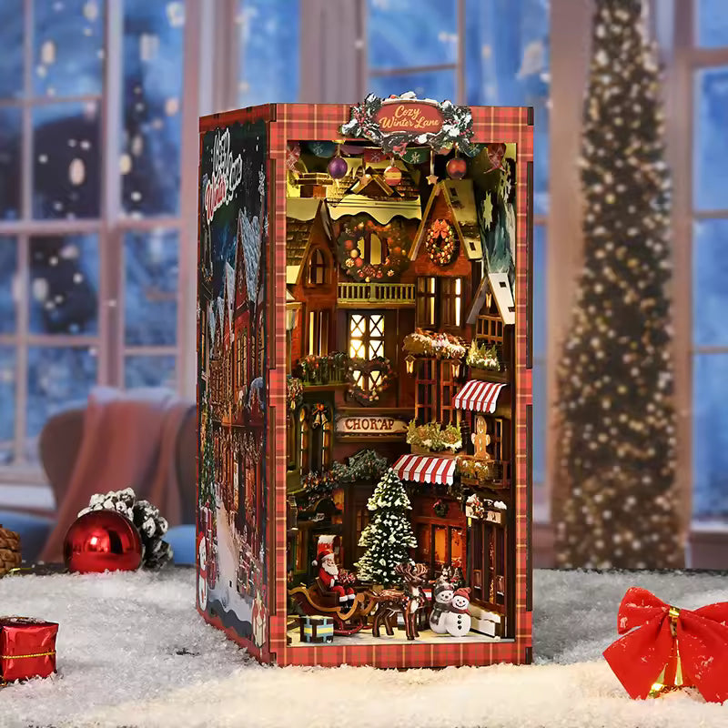 DIY book nook kit “Merry Market Lane,” featuring a warmly lit winter street with festive storefronts, snow-topped rooftops, and a softly bustling holiday vibe. A detailed DIY and crafts project perfect for holiday lovers and miniature collectors.