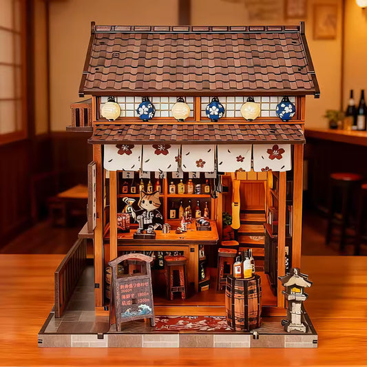 DIY miniature sake bar book nook with glowing lanterns, wooden bar seating, bamboo paneling, and rows of sake bottles, capturing the quiet atmosphere of a late-night Japanese tavern.