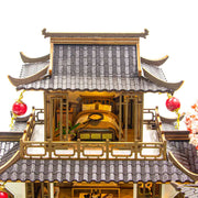 DIY miniature kit “Blossom Lantern Pavilion,” featuring a traditional East Asian-style building with curved roofs, cherry blossom trees, red lanterns, a waterfall, and glowing lights. A serene DIY and crafts project for fans of miniature homes and nature-inspired design.