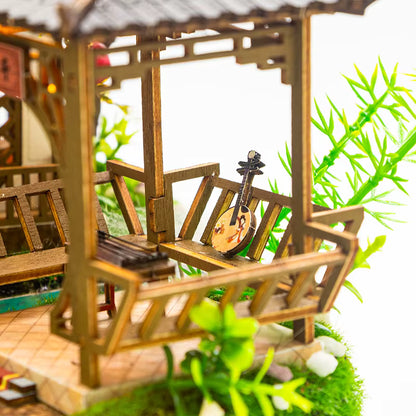 DIY miniature kit “Blossom Lantern Pavilion,” featuring a traditional East Asian-style building with curved roofs, cherry blossom trees, red lanterns, a waterfall, and glowing lights. A serene DIY and crafts project for fans of miniature homes and nature-inspired design.