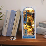 DIY and crafts lovers will enjoy this miniature book nook kit — a charming Mediterranean street scene that doubles as a bookshelf insert or home decor; perfect for craft ideas and making miniatures.