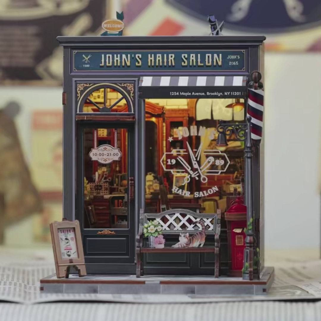 DIY book nook kit “Pomade Parlor,” featuring a vintage barbershop and hair salon interior with red chairs, mirrors, wooden shelves, and miniature grooming tools. A nostalgic DIY and crafts project for fans of retro style, miniatures, and classic salon design.