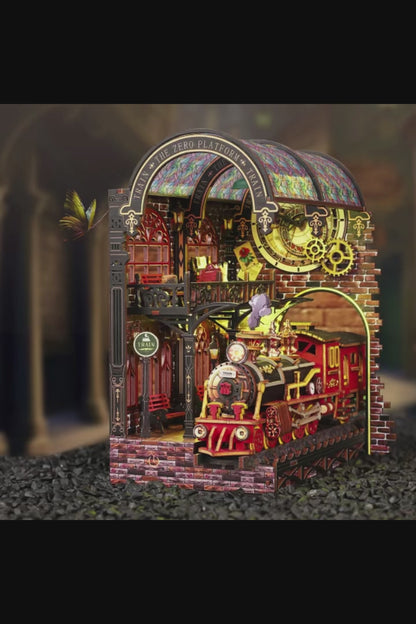 DIY book nook kit “Platform Arcane,” featuring a mechanical fantasy train station with glowing lights, gears, arched glass roof, red locomotive, and magical details. Ideal for DIY and crafts lovers, fantasy readers, and miniature train enthusiasts.