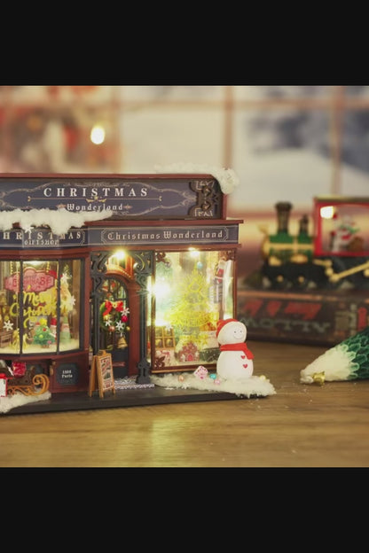 DIY miniature Christmas shop called “Jolly & Pine Christmas Shoppe,” featuring snow-dusted rooftops, holiday lights, a sleigh, Christmas tree, and cozy window displays. Ideal for holiday crafts, DIY mini home kits, and miniature house collectors.
