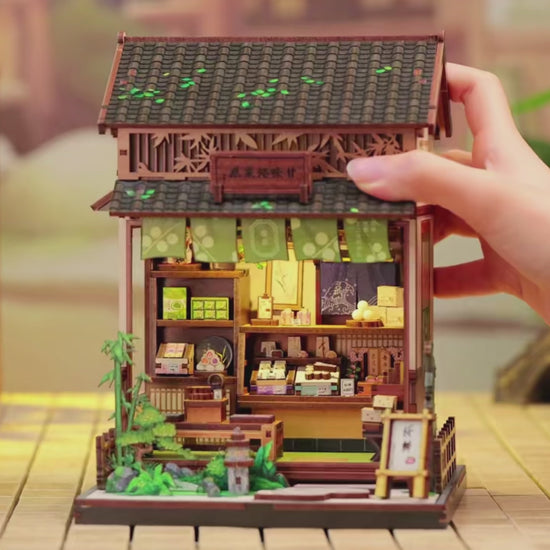 DIY mini house kit “Japanese Sweets Store,” featuring a traditional candy and wagashi shop with miniature desserts, wooden shelves, hanging banners, and tiny gift boxes. A detailed DIY and crafts project perfect for fans of Japanese culture and making miniatures.